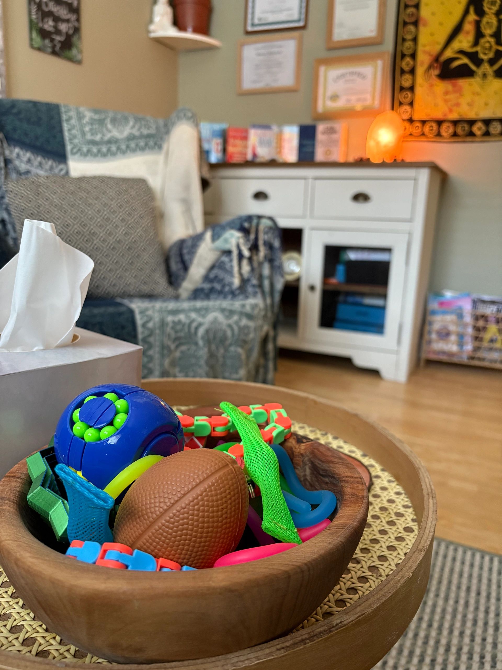 Toys in a wooden bowl on a table in a cozy living room.