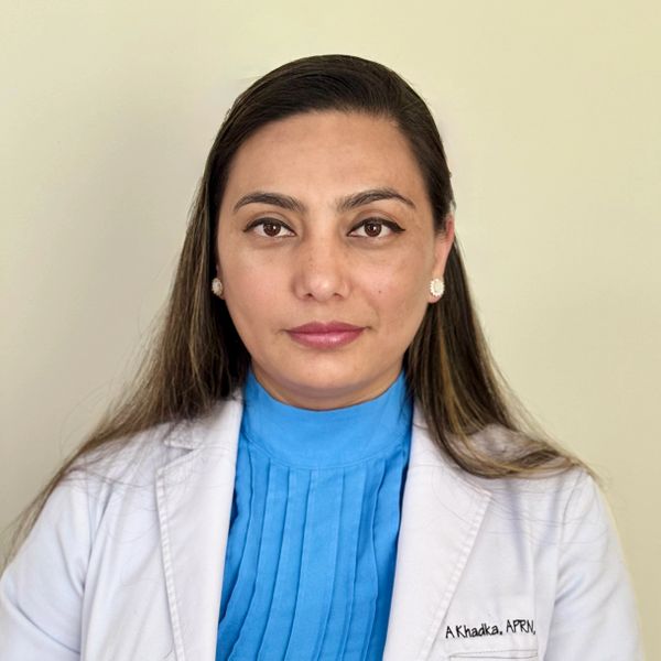 Professional woman in medical attire with a calm expression.