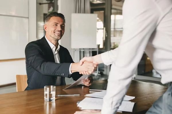 Two professionals shaking hands during a business meeting.