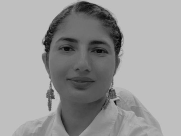 Woman in a white shirt smiling at the camera.