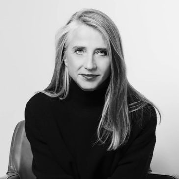 Black and white portrait of a woman sitting on a chair.