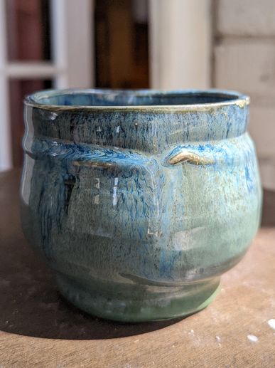 small snake camouflaged and wrapped around the upper portion of this cool green and blue mug