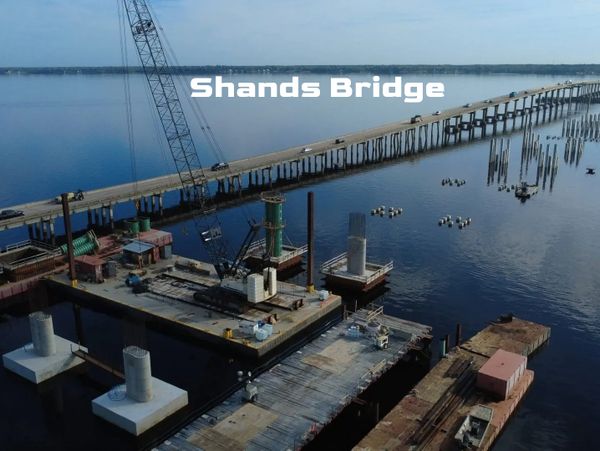 Aerial view of Shands Bridge construction over a calm river.