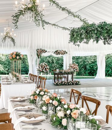 Wedding set up with floral arrangements and greenery on a ceiling