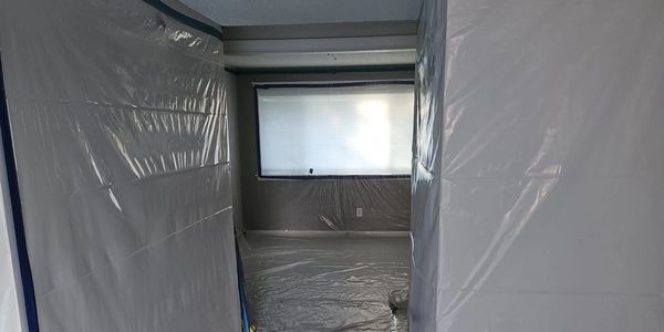 Room covered in plastic sheets for painting or renovation.