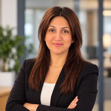 Confident woman in black blazer with arms crossed.