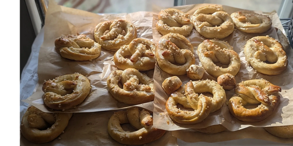 Freshly baked soft pretzels on parchment paper.