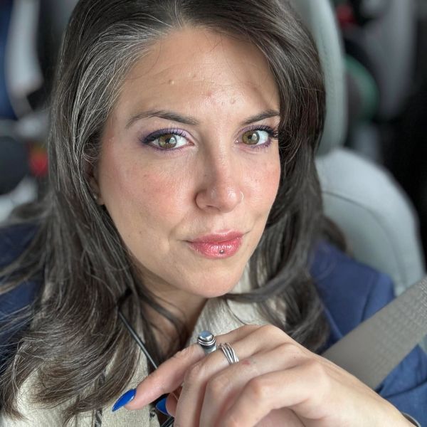 Close-up of a woman with striking green eyes and dark hair.