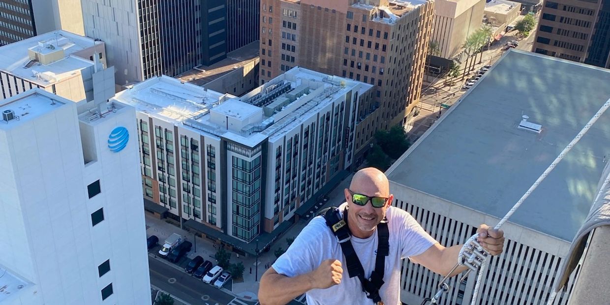 Epic Shine owner climbing a high-rise building to clean its windows