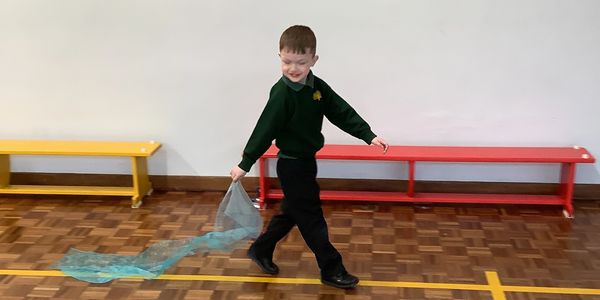 A young person exploring flow in the space with soft material.