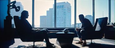 Two men in a serious conversation in an office.