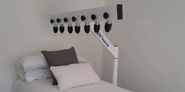 A bed with a therapy lamp attached above.
