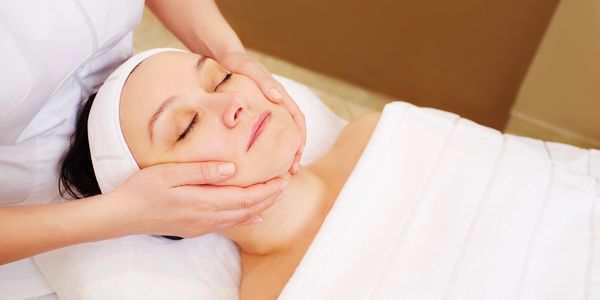 Woman receiving a facial massage.