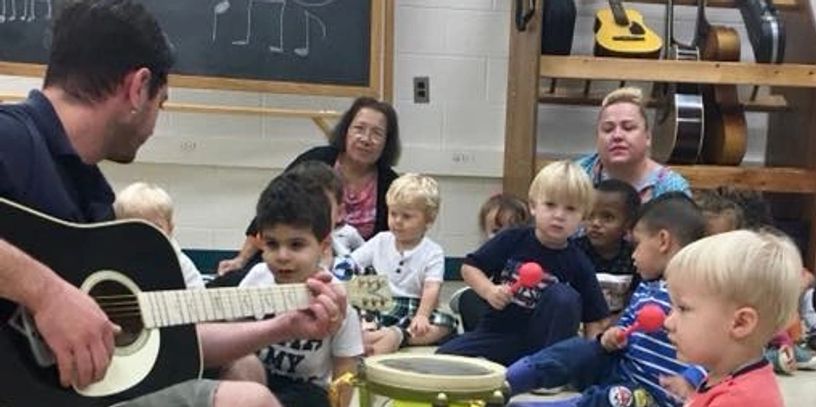 A picture of the teacher playing guitar 