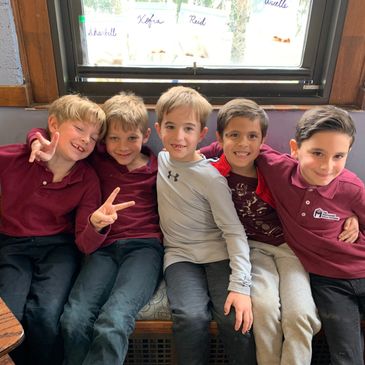 Group of kids sitting on a sofa smiling at camera