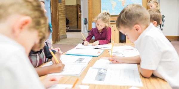 A picture of kids studying and writing on paper