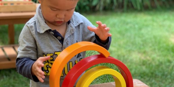 A picture of an Asian toddler playing with his toys 