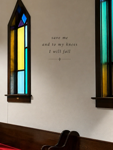 Stained glass windows and a spiritual quote inside a church.