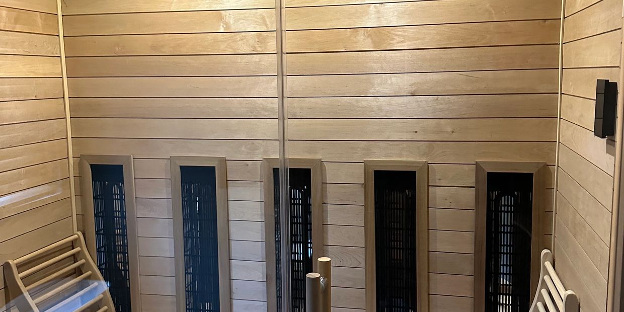 Interior of a wooden sauna with benches and heating panels.