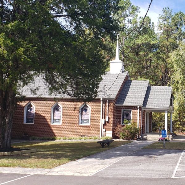 Small brick church building with a white steeple.