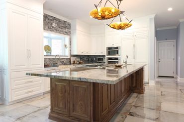 Luxurious kitchen with marble island and white cabinetry.