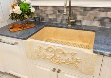 Elegant farmhouse kitchen sink with carved design.