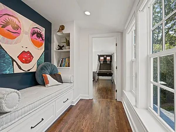 Bright hallway with built-in bench and large windows.