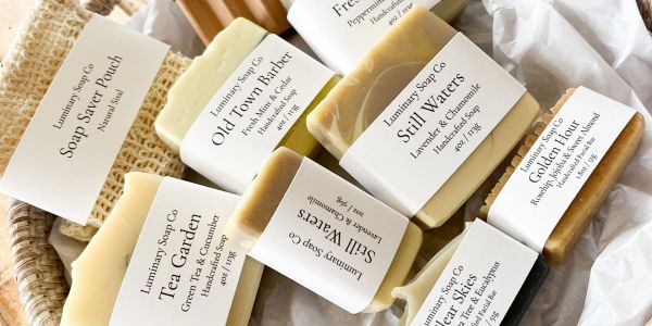 Various natural soaps from Luminary Soap Co. displayed on a cloth.