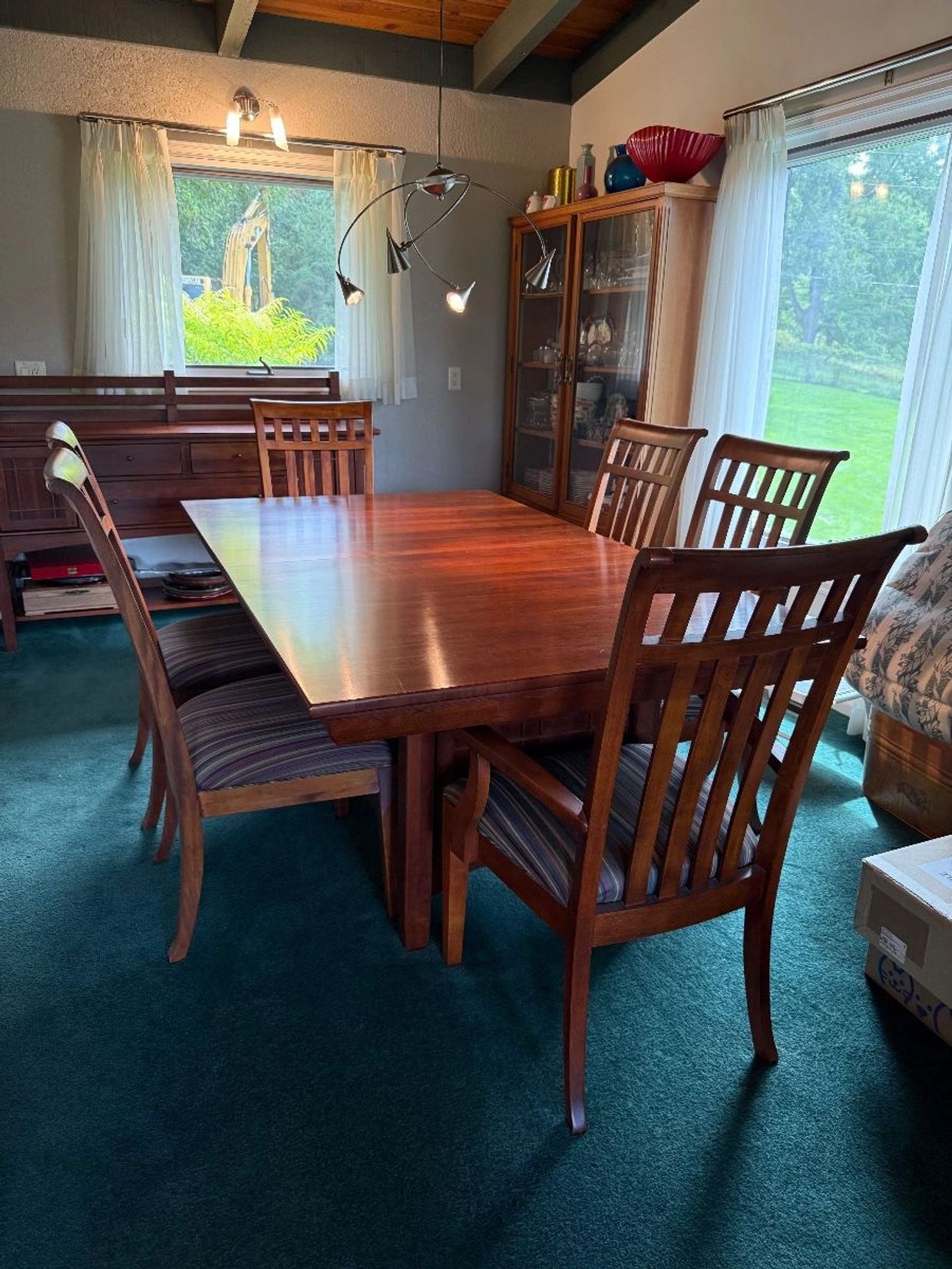 Wooden dining table set with six chairs in a cozy dining room.