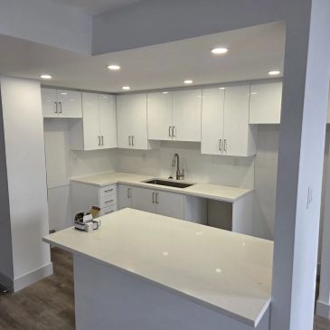 Modern white kitchen with island and sleek cabinets.