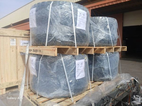 Stacked industrial metal coils wrapped in plastic on wooden pallets.