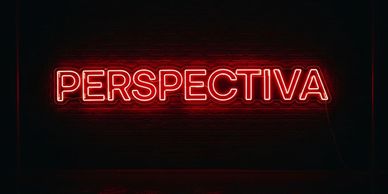 Red neon sign displaying the word 'PERSPECTIVA' against a dark brick wall.
