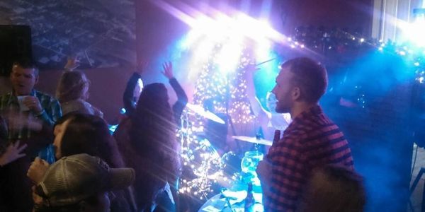 People enjoying a live music event with colorful lights.