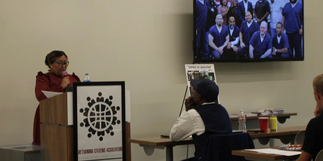 A woman speaks at a podium during a Returning Citizens Association event.