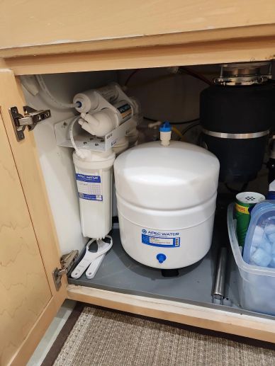Reverse osmosis water filtration system under a kitchen sink.
