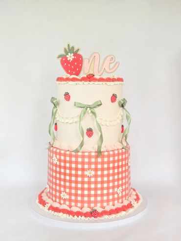 Two-tier strawberry-themed first birthday cake.