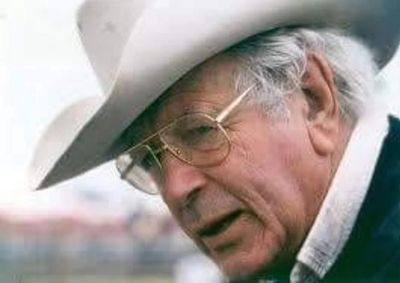 Elderly man wearing a white cowboy hat and glasses.