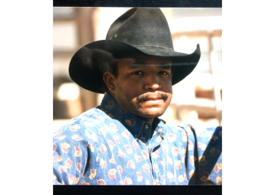 Man in cowboy hat with patterned shirt.