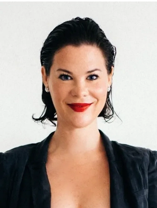 Picture of a business woman smiling wearing red lipstick and a blazer