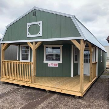 Green barn-style cabin with wooden porch and white trim, labeled 16 ft. wide.