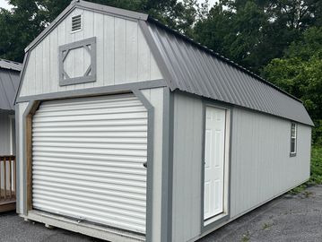 Portable garage with floor, walk in door, window, lofts, & roll up door