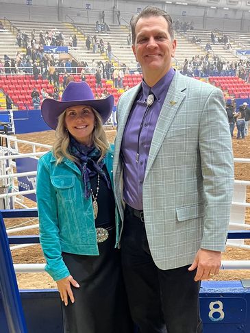 Smiling couple at an event with cowboy attire.