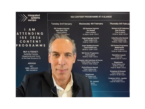 Man attending ISE 2026 Content Programme with schedule board in background.