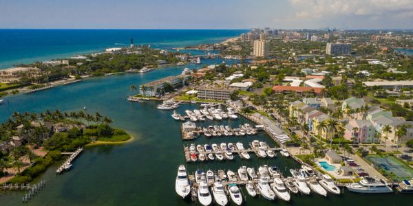 Aerial view of a marina with numerous boats docked near a coastal city.