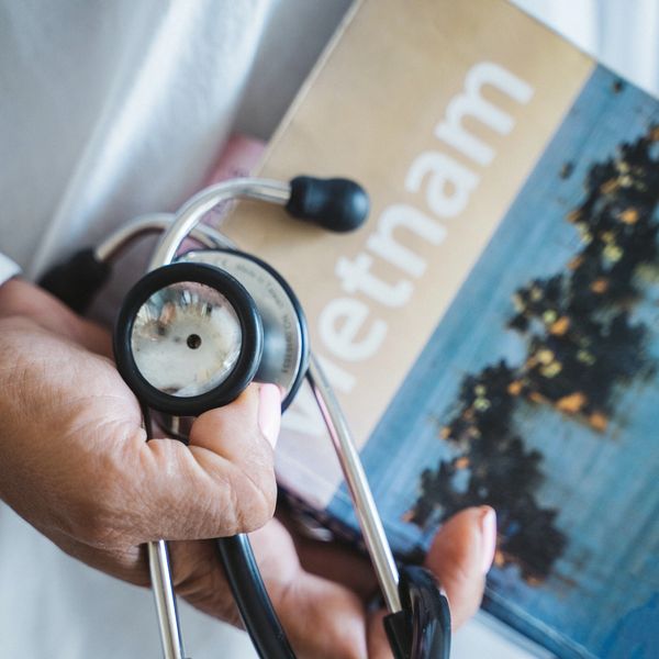 A doctor holds a stethoscope and an informational pamphlet in their hands.
