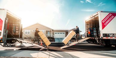 2 Bend Brothers Moving Trucks with Movers Coming down the walkboards with boxes