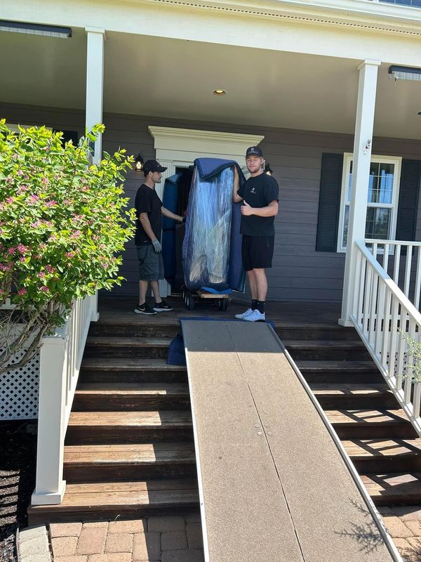 Baby Grand Piano Movers in front of moving truck with lift gate. Piano is properly stored