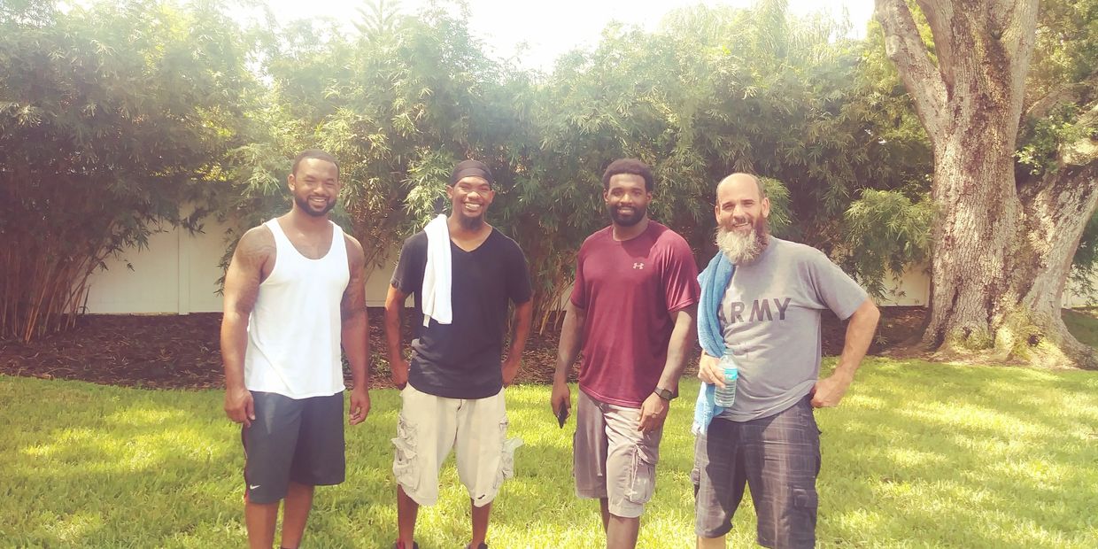 Four men smiling after a moving job.