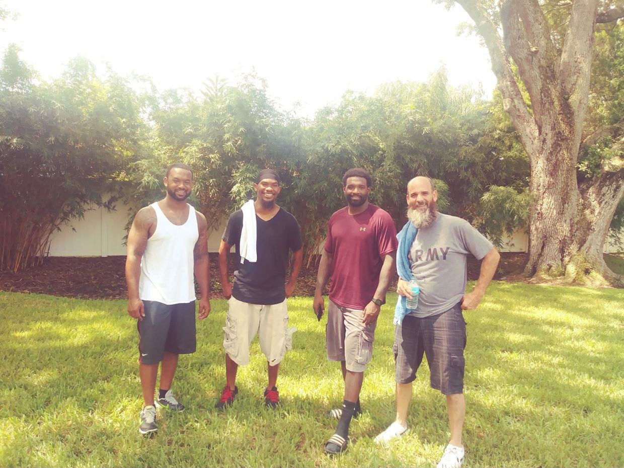 4 Military Veterans smiling into camara after completing a moving job.