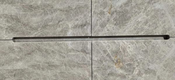A close-up of a stone surface with a narrow groove.